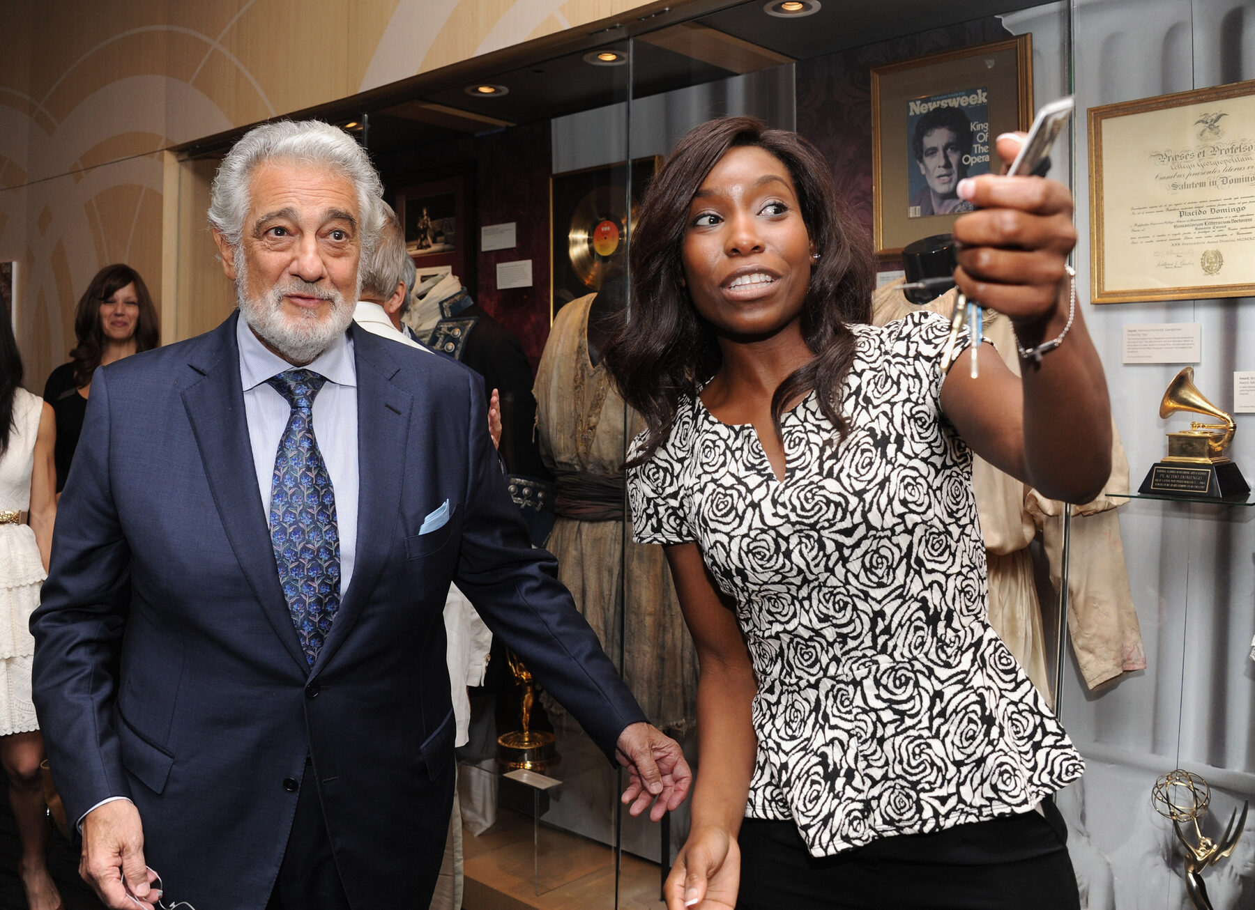 Nwaka Onwusa with Pl&aacute;cido Domingo beside a display case of his awards and memorabilia