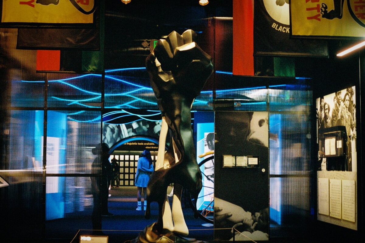 Raised-fist sculpture and exhibition environment inside Wake Me When I&rsquo;m Free
